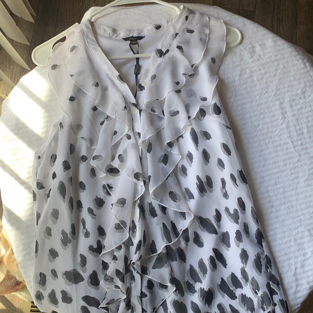 Black and White blouse. 100% polyester. It’s soft frills give a cute but elegant